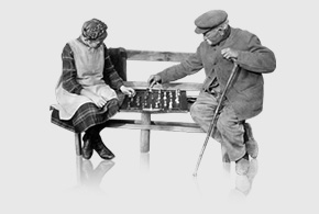 altes Paar spielt Schach auf Bank